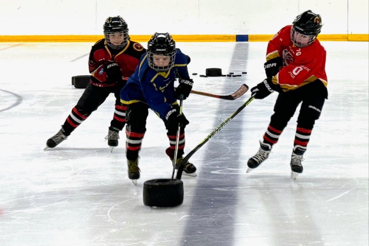 Jonge speler met de puck op het ijs