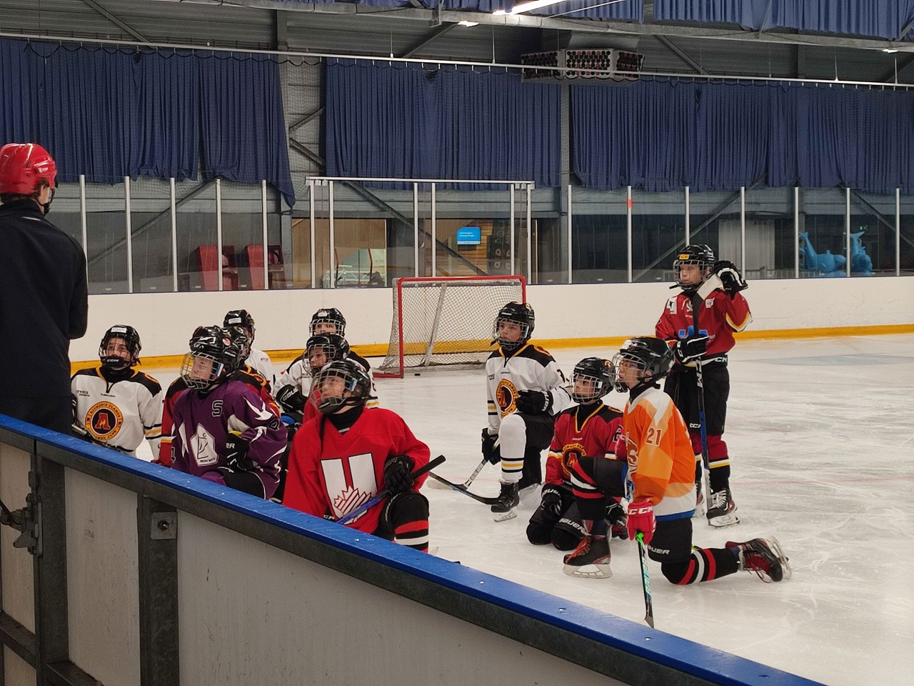Coach achter de bank met jeugdspelers